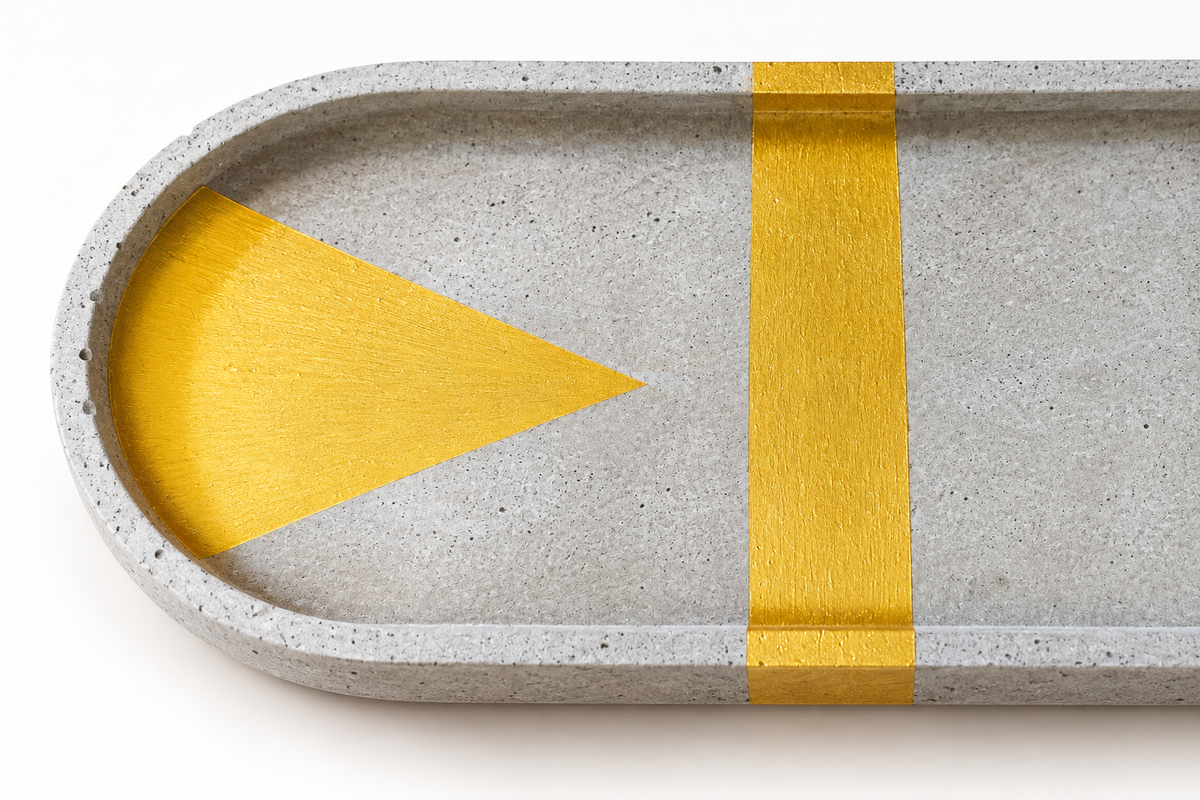 XL oval concrete coaster – detail of the gold triangle with cross stripe, surface, and edge