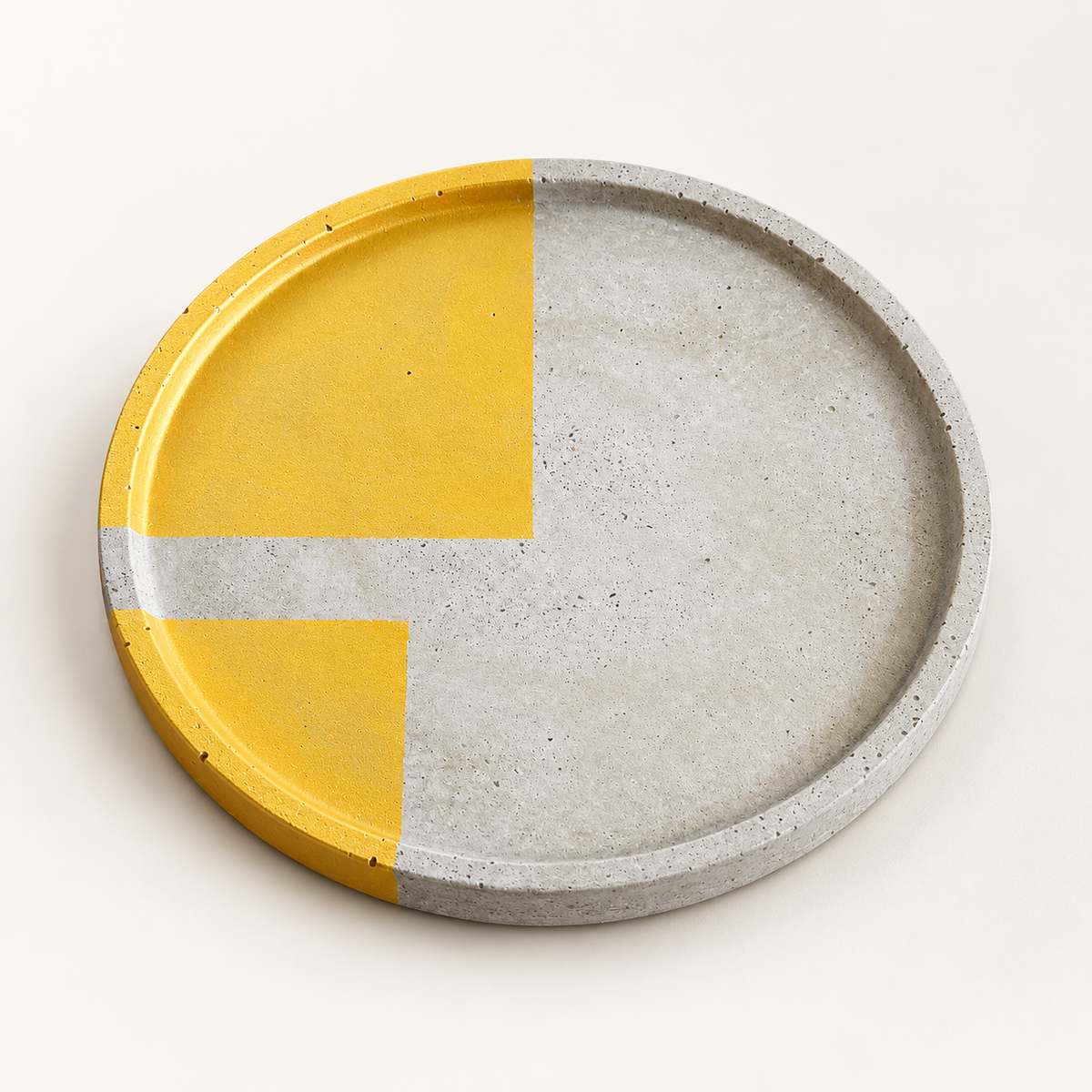 Large round concrete coaster with two gold-tone sections and a concrete crossbar