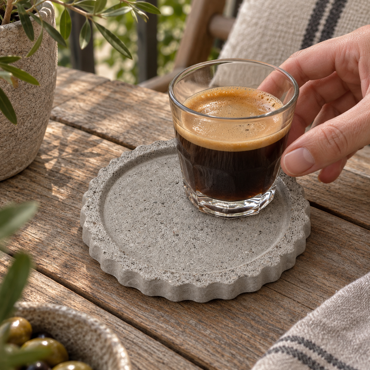 Round concrete coaster with scalloped edge – natural concrete – shown in use