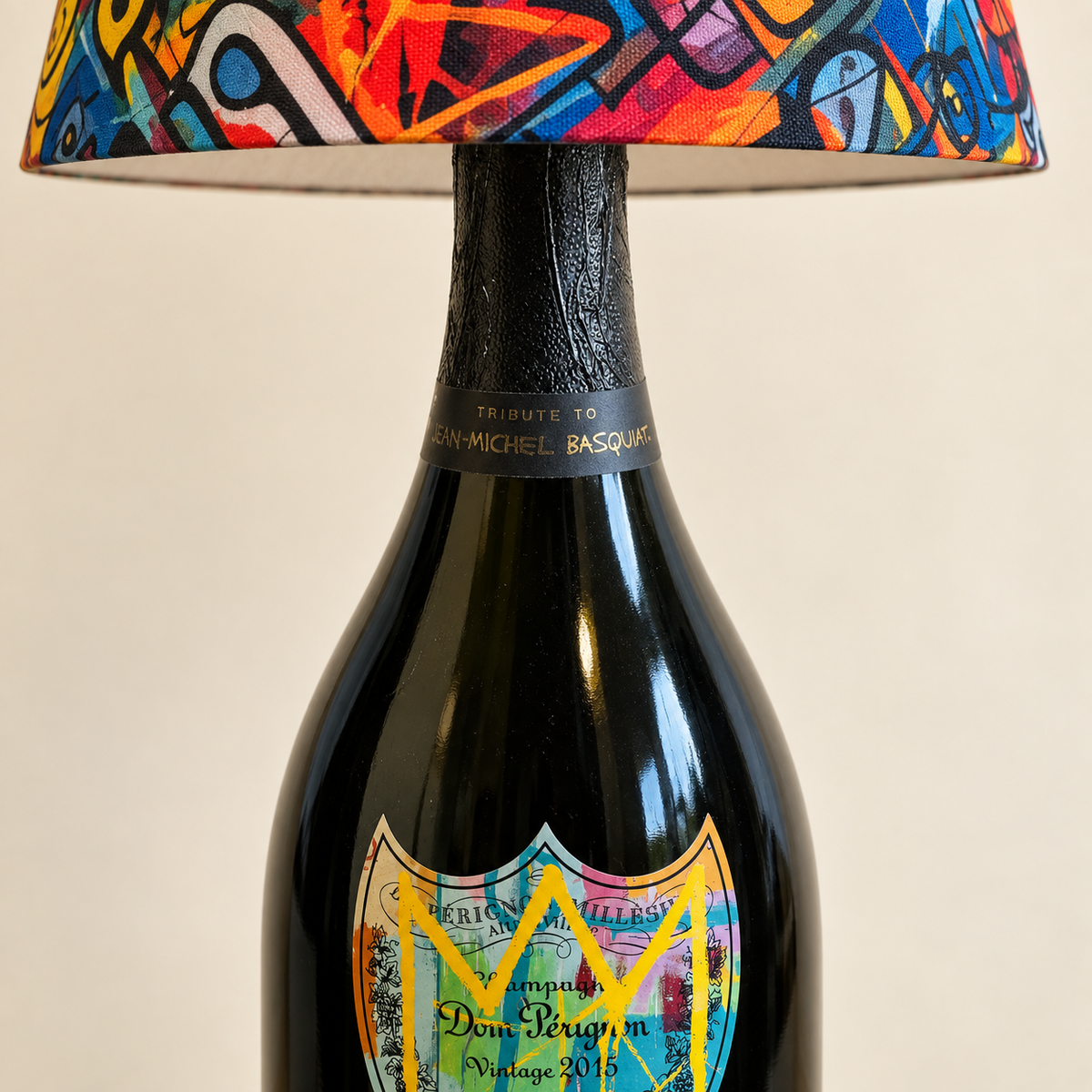 Close-up of the bottle neck, edition label, and fabric shade on the yellow Basquiat bottle lamp.