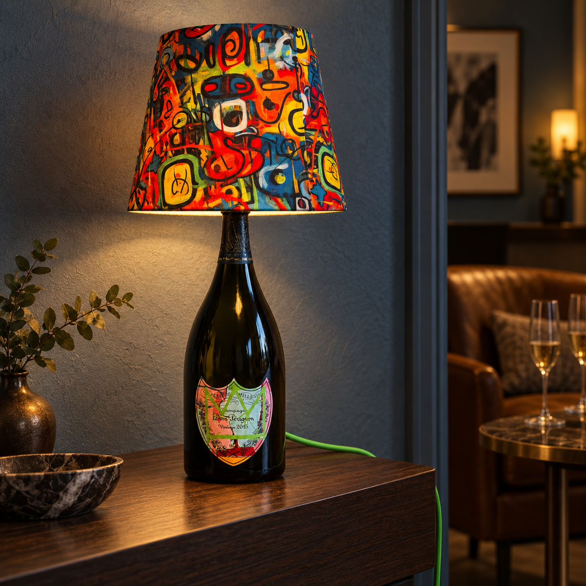 Illuminated green-crown Dom Pérignon Basquiat bottle lamp in an evening lounge – AI-edited product image.