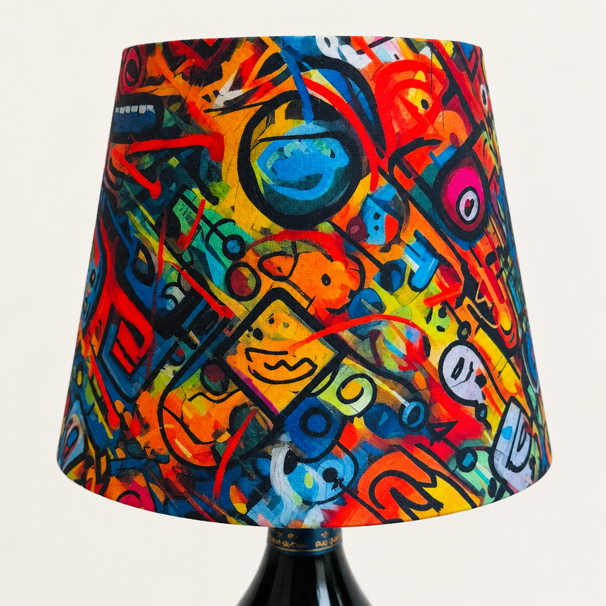 Close-up of the colorful fabric shade on the green-crown Dom Pérignon Basquiat bottle lamp – AI-edited product image.