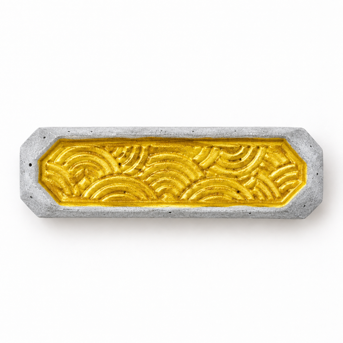 Concrete chopstick rest with gold-tone wave relief – horizontal top view on a light background.