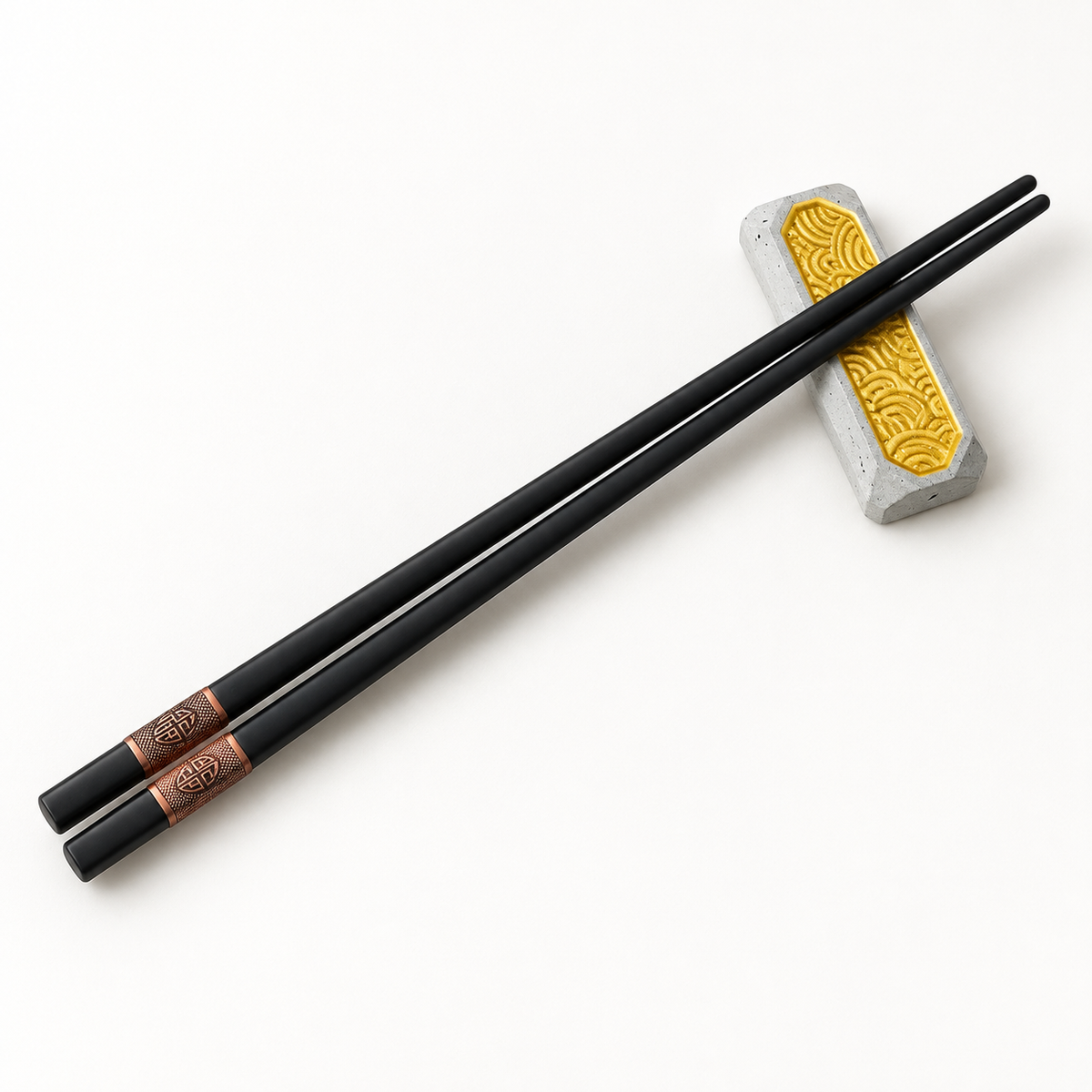 Concrete chopstick rest with a pair of black chopsticks placed on top against a light background; chopsticks shown for illustration.