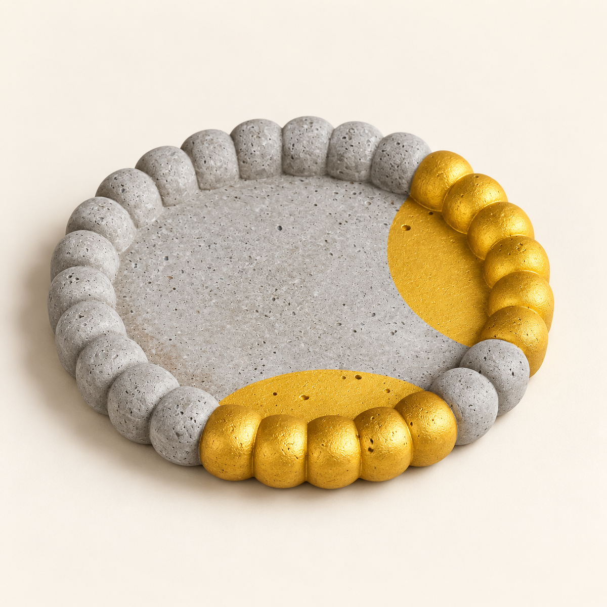 Small ribbed concrete coaster – gold arcs – angled view