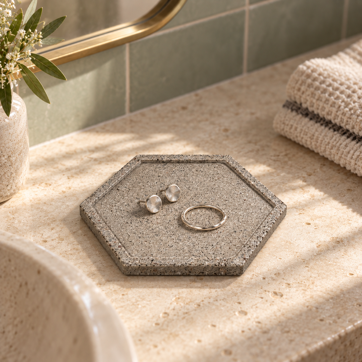 Natural concrete hexagon coaster used as a jewelry tray in a bathroom