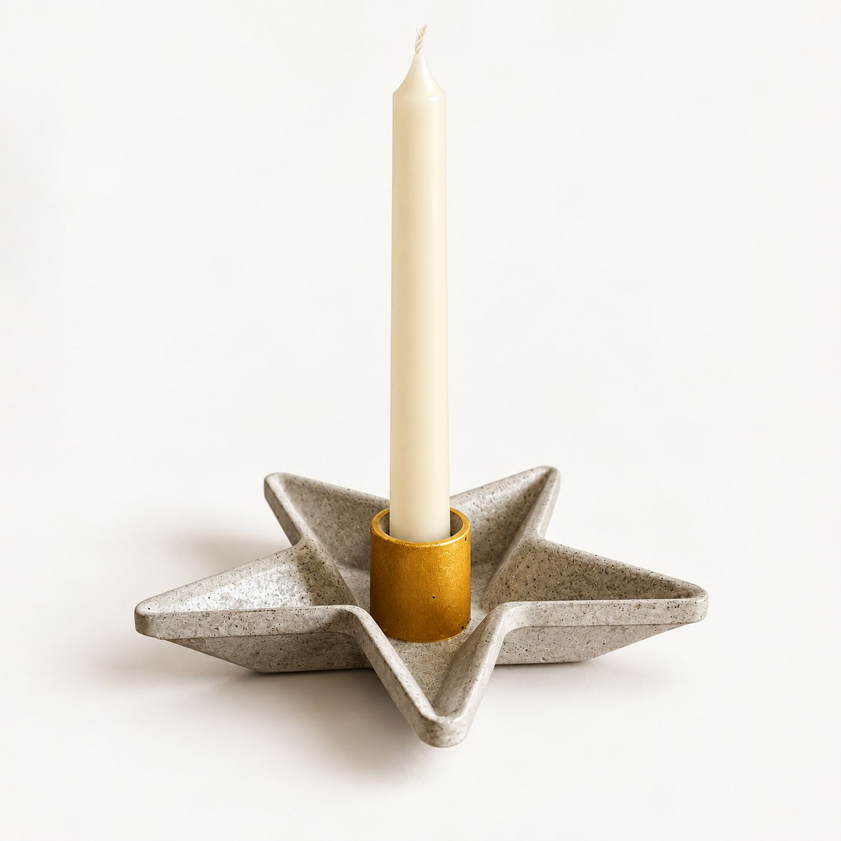Star-shaped concrete candle holder with gold candle cup and taper candle