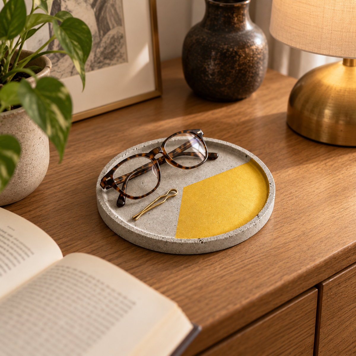 Large round concrete coaster with wide gold-tone segment used as a catchall in a reading nook