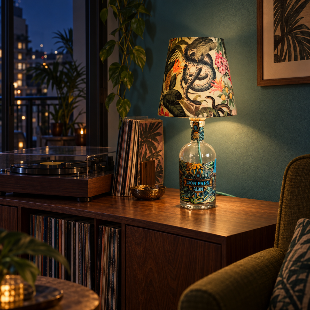 Don Papa Alon Flaschenlampe eingeschaltet neben einem Plattenspieler am Abend