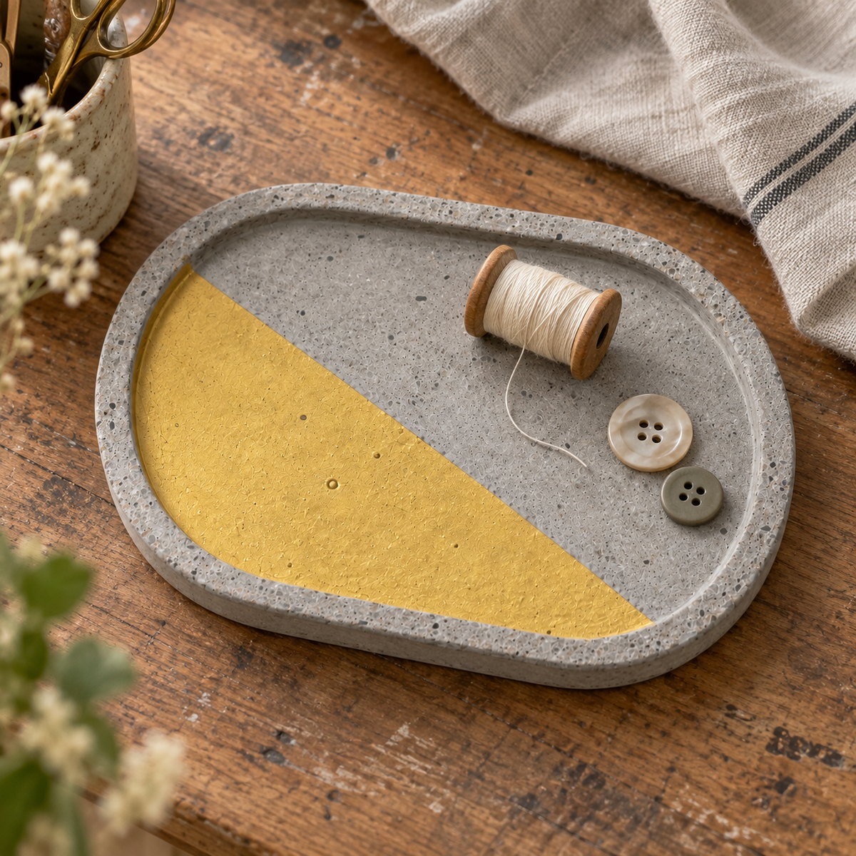 Oval concrete coaster – organic gold-tone area – shown in use