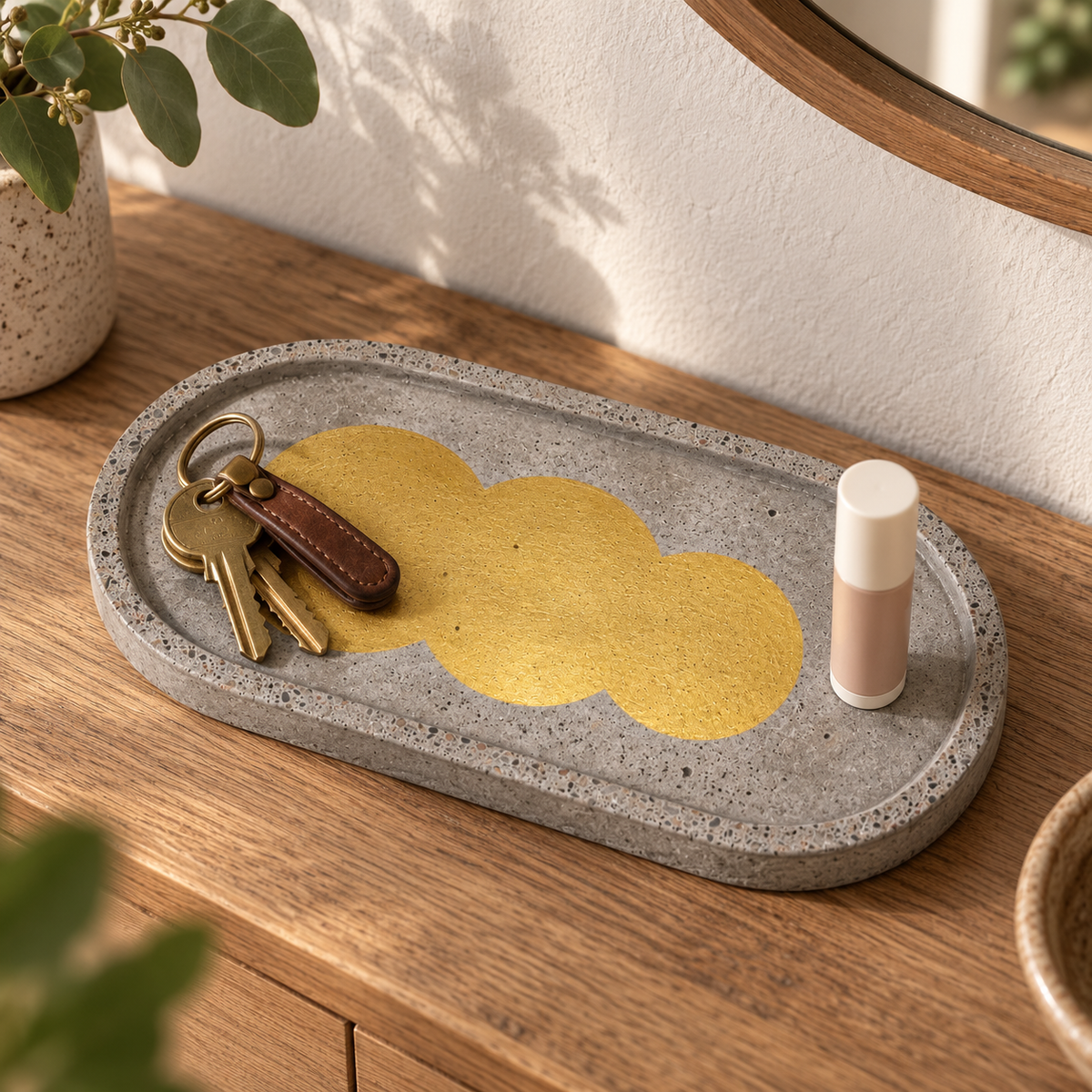 Elongated oval concrete coaster – row of gold-tone circles – shown in use