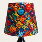 Close-up of the colorful fabric shade on the green-crown Dom Pérignon Basquiat bottle lamp – AI-edited product image.