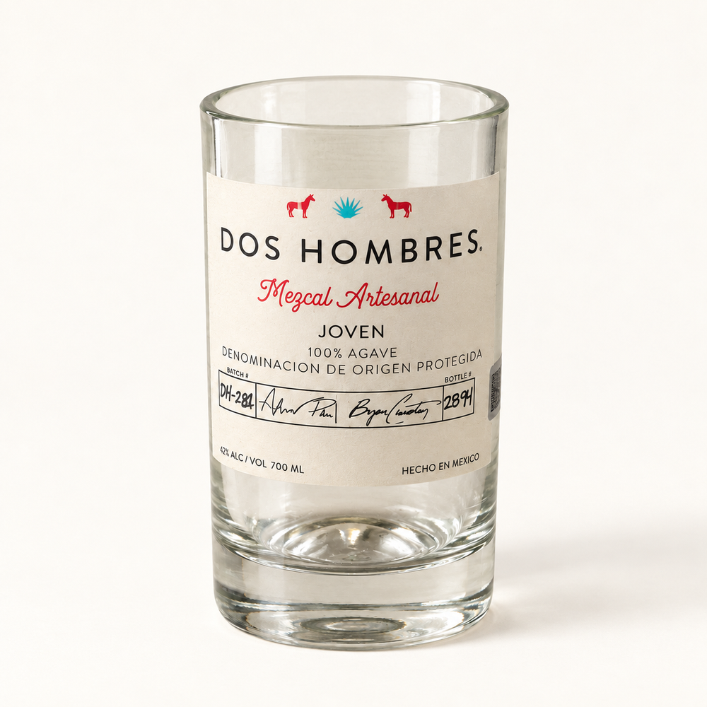 Handmade bottle vase from clear Dos Hombres mezcal bottle glass against a light background