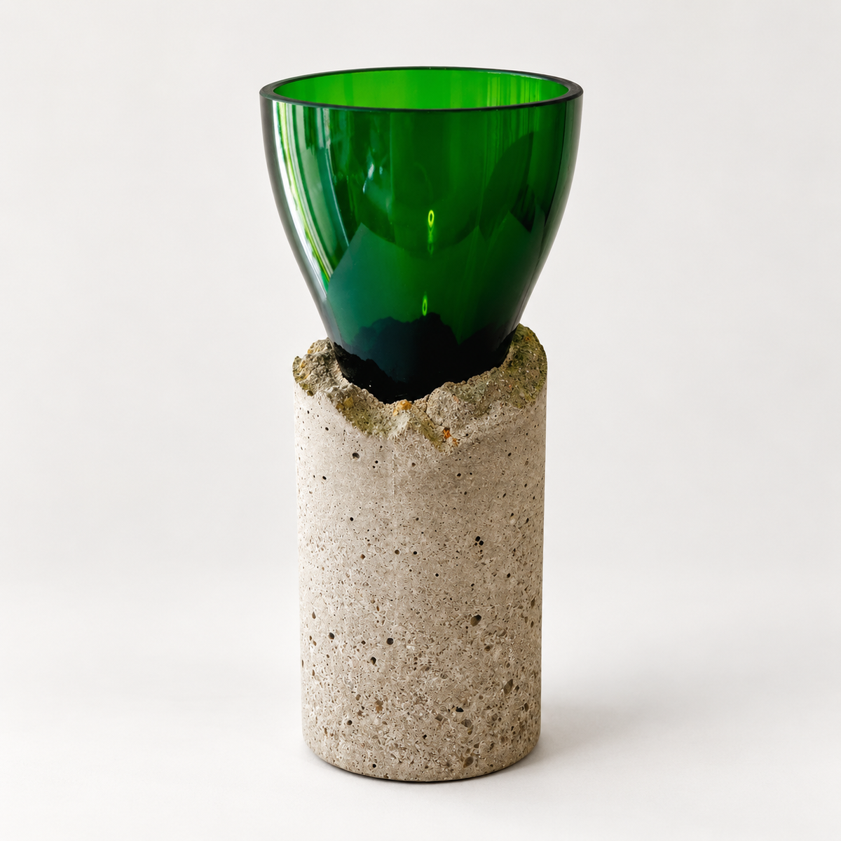 Green glass-and-concrete vase with chalice-shaped glass and tall grey concrete base