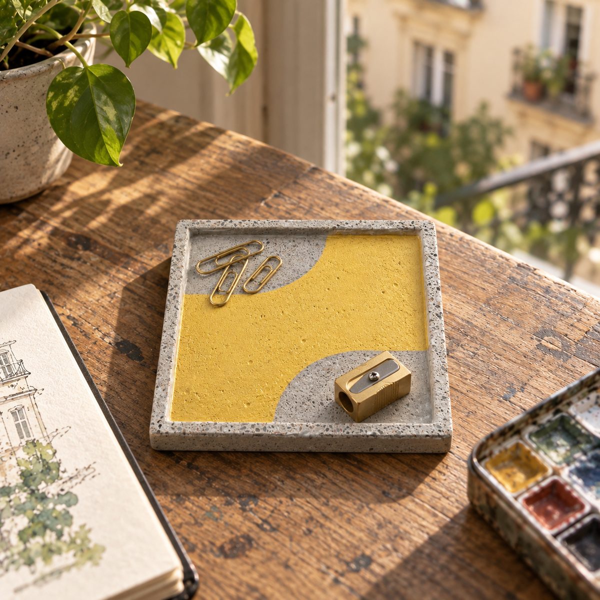 Square concrete coaster with organic gold-tone band in an artist’s studio